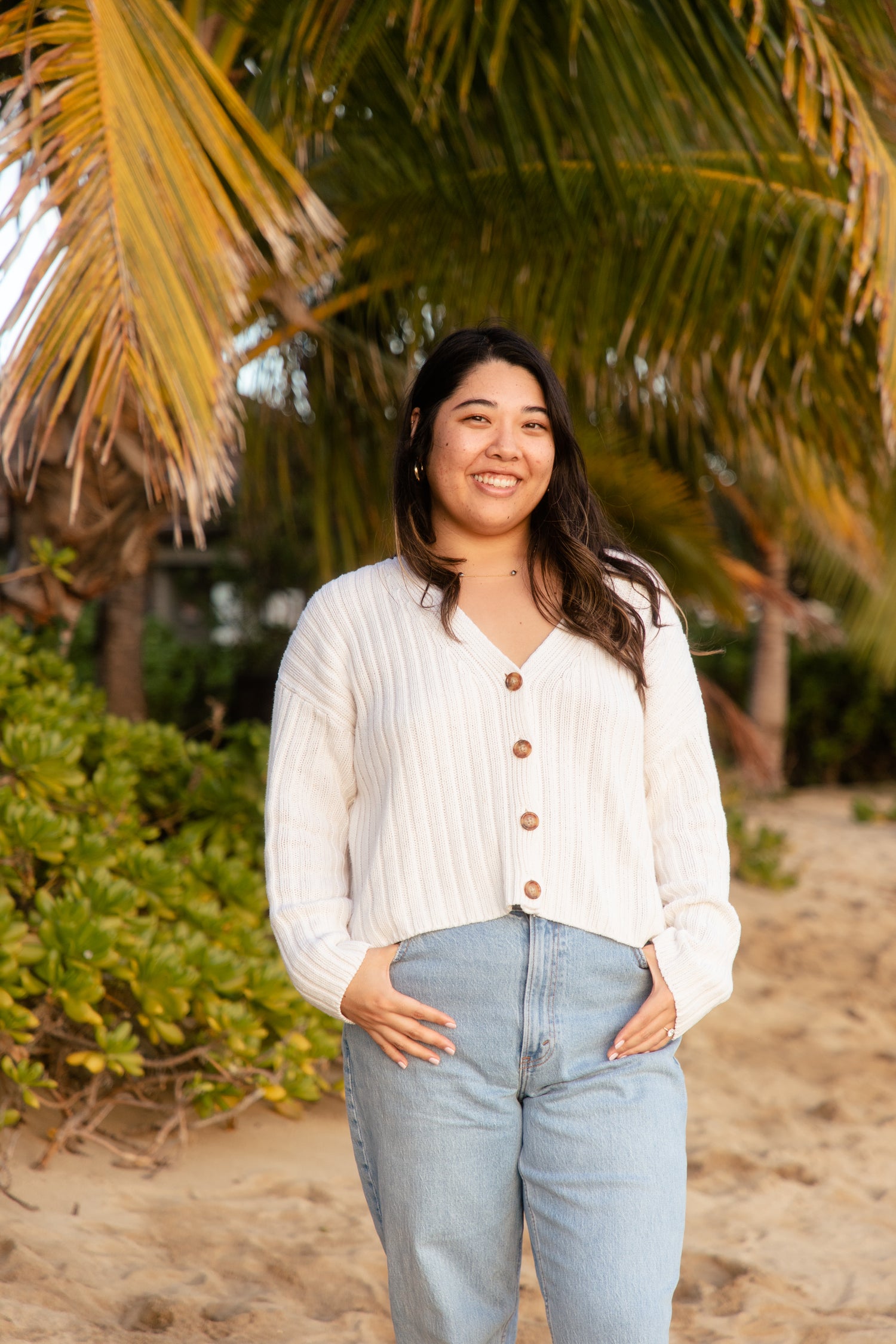 Woman standing on a beach with palm trees in the background