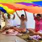 parents with babies under a colorful parachute indoors