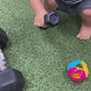 a toddler boy playing with a rattle at the gym